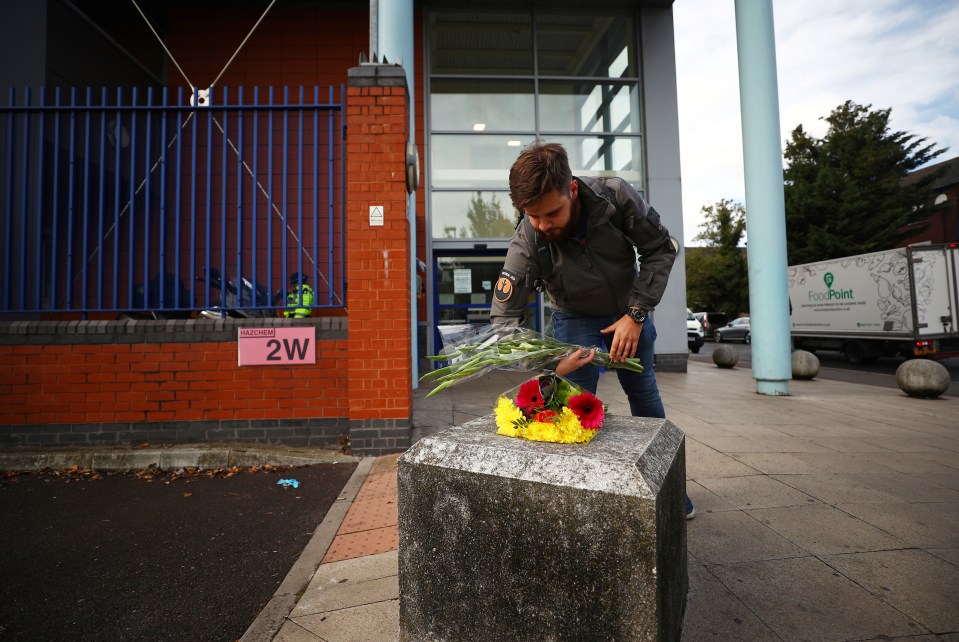 A man leaves flowers in tribute to the killed officer