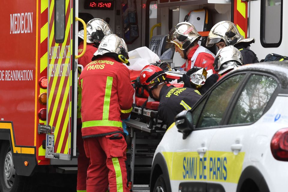 Emergency workers help a victim into an ambulance