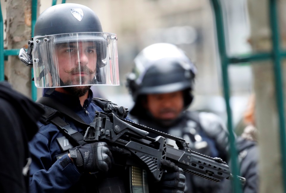 French police armed with guns stand guard