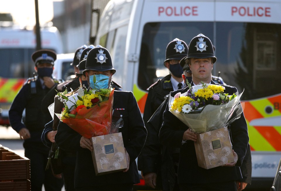 Police officers arrive to pay respects outside the custody centre 