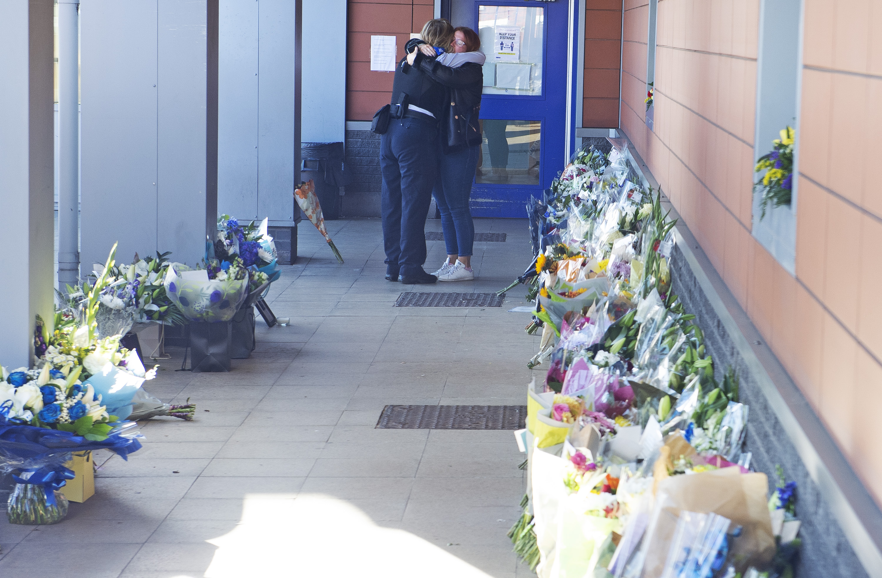 Colleagues hugged as they looked at the dozens of flowers left for the sergeant