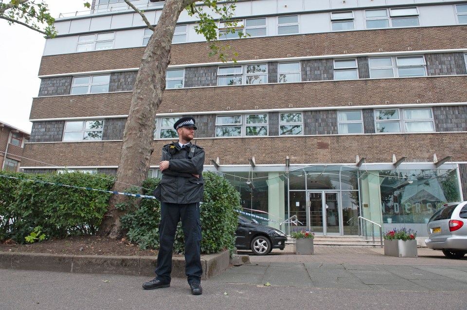 An officer stands guard outside the block of flats where the suspect was arrested