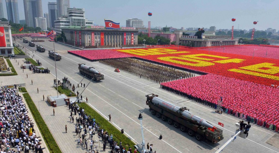 Missiles are wheeled past huge crowds waving flags in Pyongyang