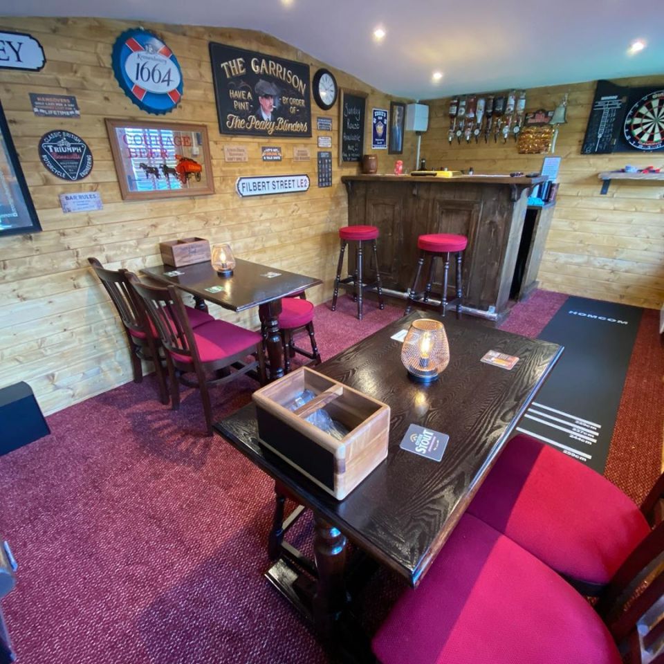 The pub has a dart board and a Peaky Blinders sign