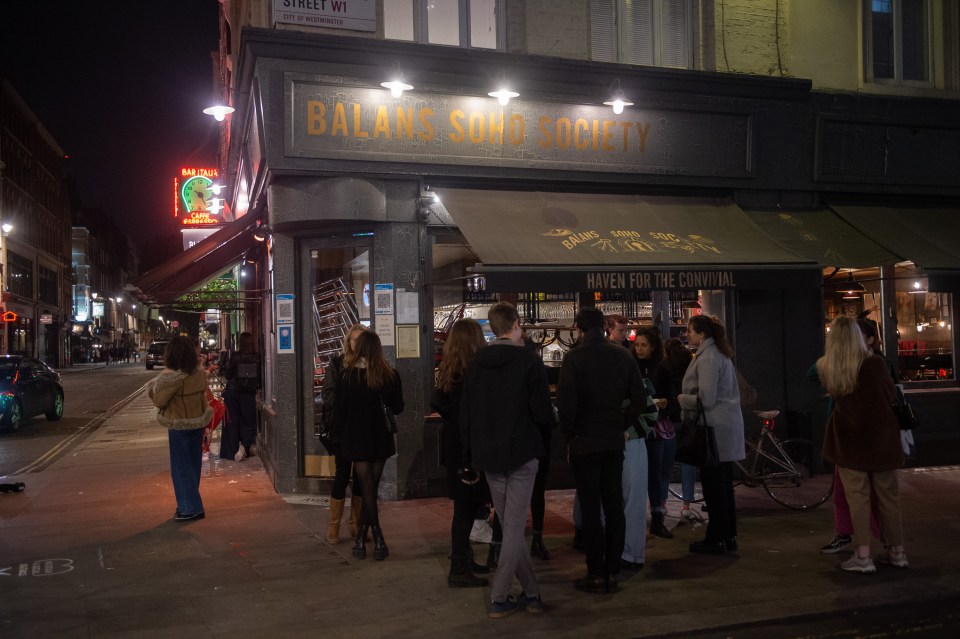 Londoners gather outside a bar after it shut at 10pm for Boris Johnson's curfew 