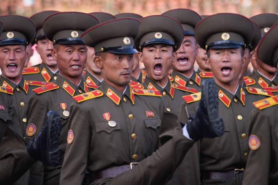 North Korean soldiers goose step in a parade