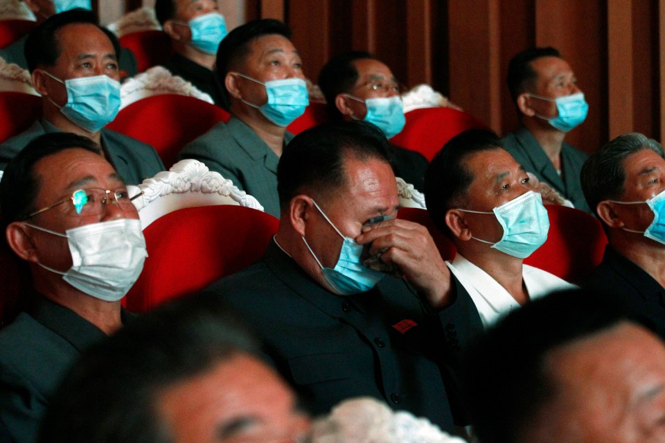 North Korean officials weep at a celebration event marking the 75th anniversary of the Communist Party