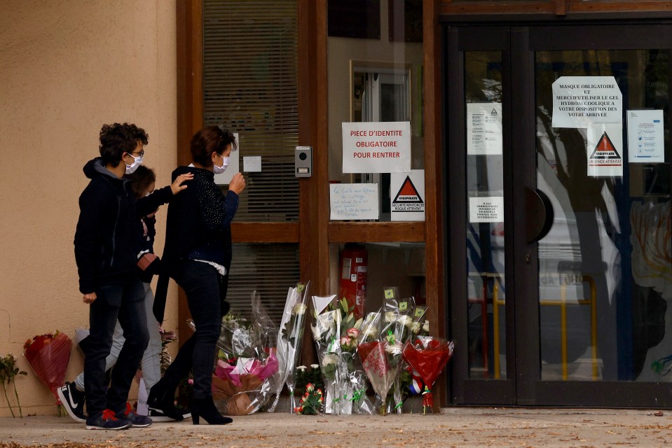 Mourners outside the school where Mr Paty taught