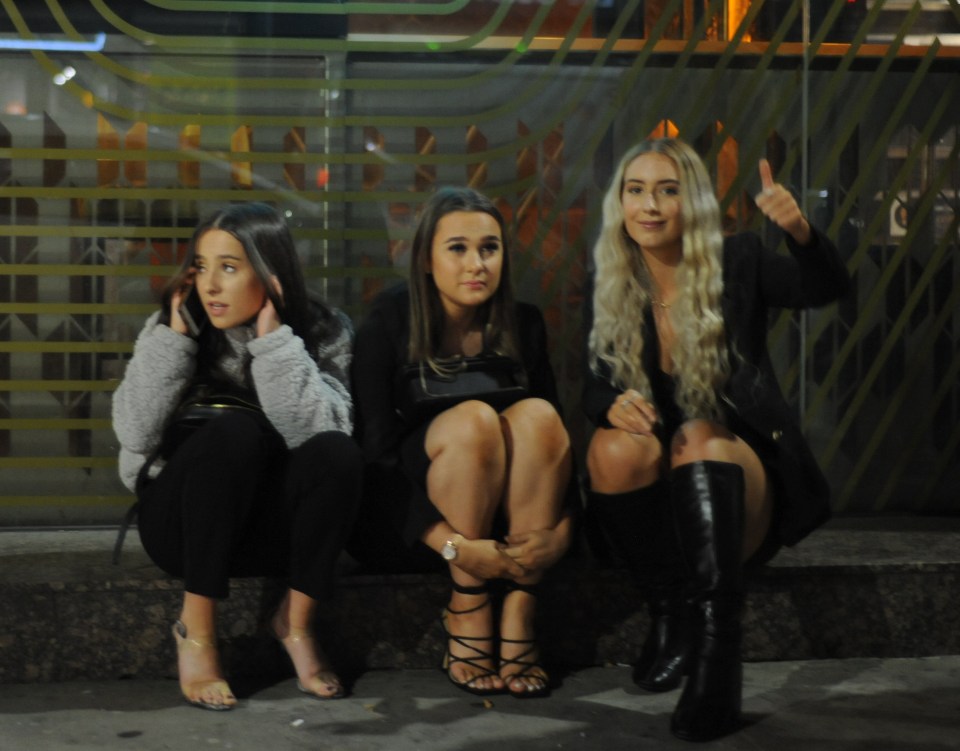 Friends sit on the streets of Manchester after partying over the weekend