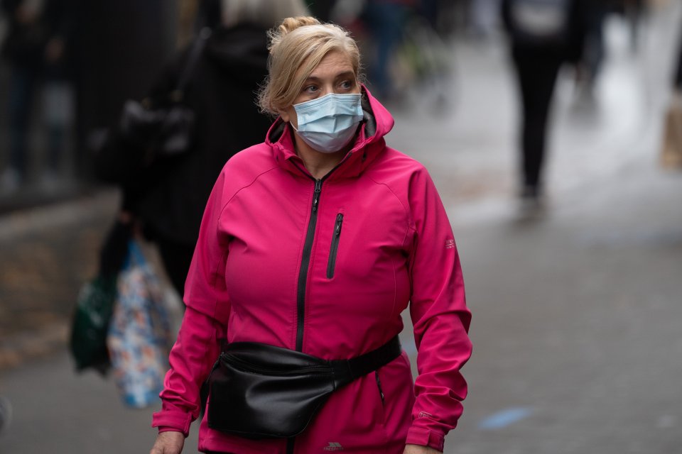 A woman wearing a mask walks through Nottingham city centre