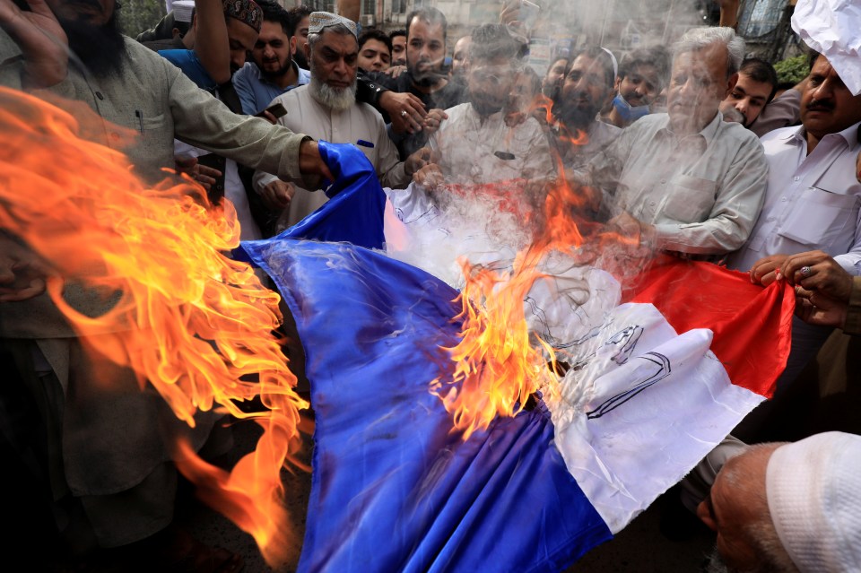 Protesters in Peshawar, Pakistan burn a French flag