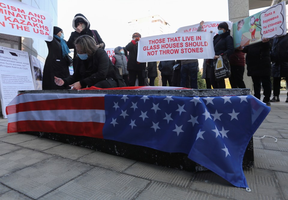 Demonstrators carried banners saying 'Stop racism and discrimination' as the coffin was draped in the US flag 