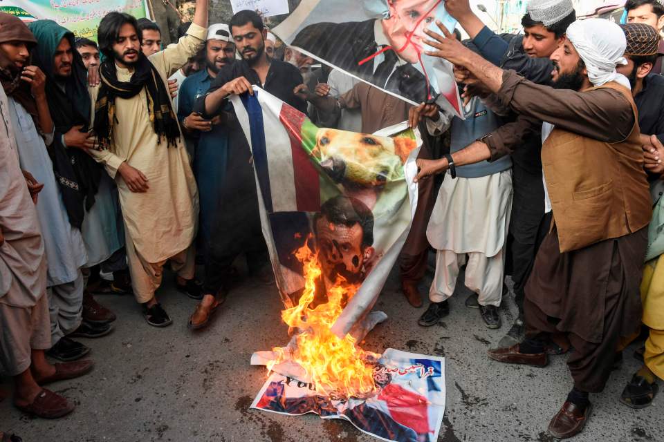 Demonstrators burn pictures of Macron during protests in Pakistan