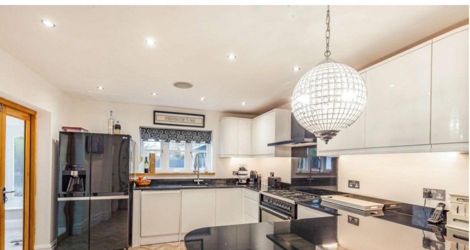  The kitchen features a round chandelier