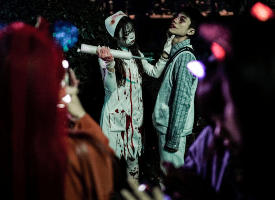 A reveler mimics giving an injection to a patient during Halloween celebrations