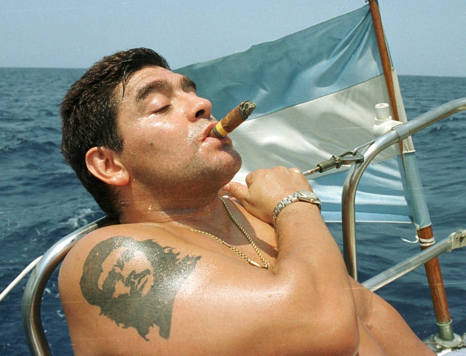 Diego Maradona was known for his love of the high life as he is pictured puffing on a cigar while enjoying the sunshine