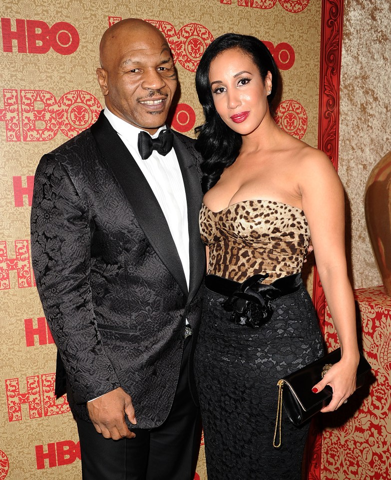 mike tyson and his wife pose for a picture in front of a hbo wall