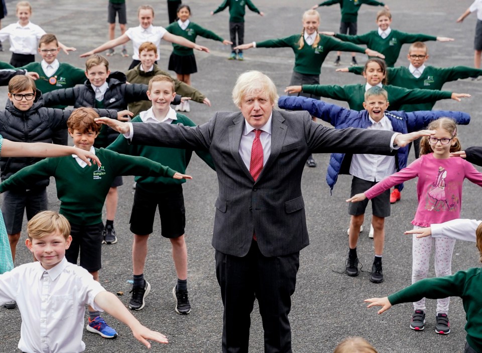 Prime Minister Boris Johnson is pictured with primary school pupils in June this year, three months after schools across the UK were closed