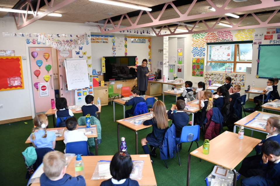 Year Two pupils listen to their teacher during their first day of school in East London on September 3