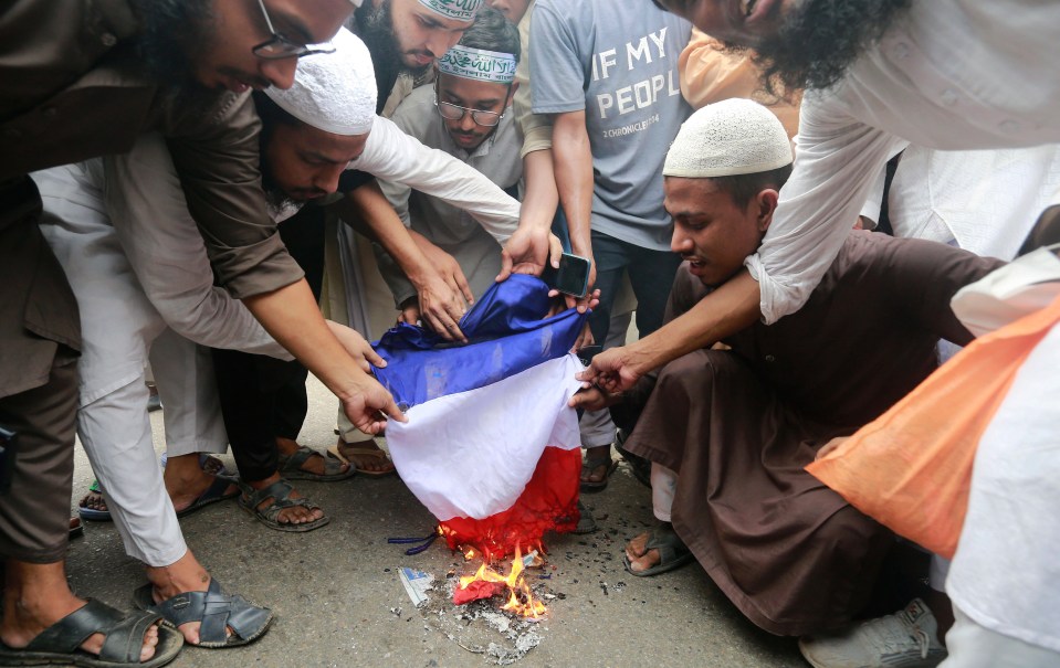 Members of the Hefazat-e-Islam Bangladesh burn a flag near the French Embassy in Dhaka