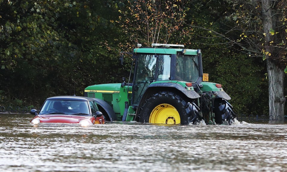 A tractor pushes its way through the flooding 