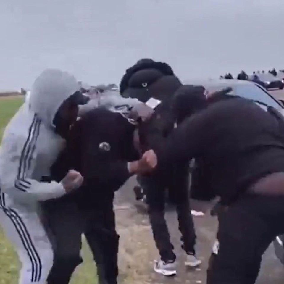 A man wearing a grey tracksuit joins in the fight