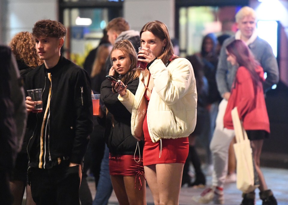 A group share a drink on the street in Portsmouth as lockdown looms