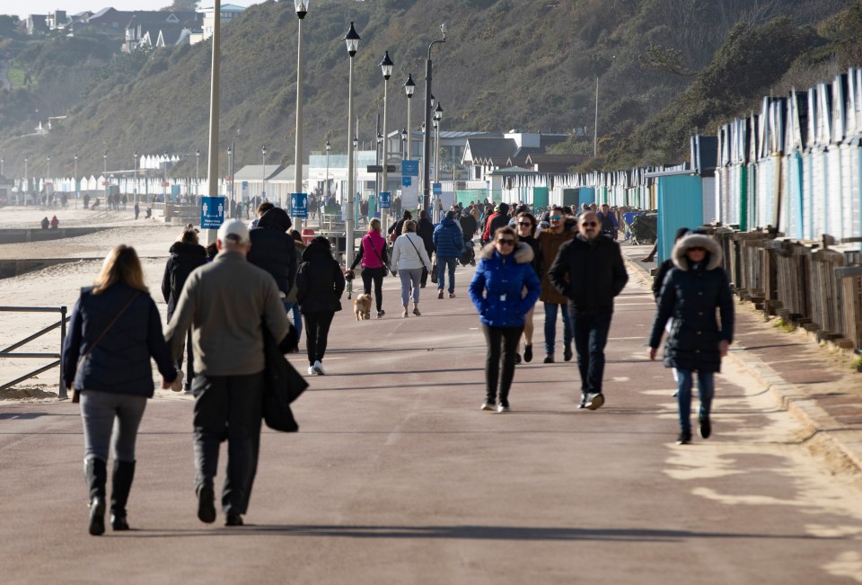 Members of the public walk alongside Bournemouth beach despite the Government's order to stay home 