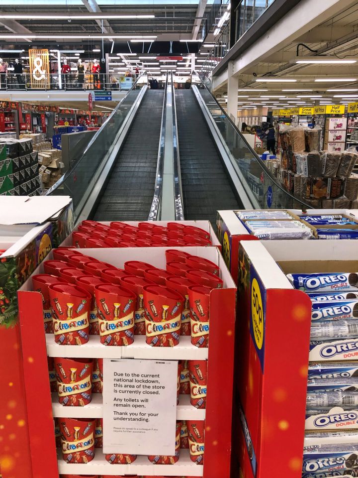 The travelator at a Tesco supermarket in Cambridge is blocked off to close the clothing and general merchandise department