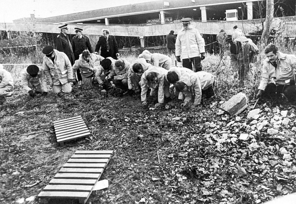 Forensic officers search the wasteland where the body of Jacqueline Hill was discovered in 1980