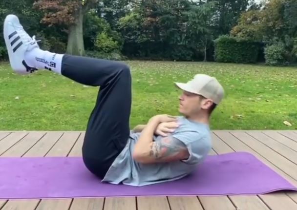 Mesut Ozil worked his core in a hat during a private outdoor work-out