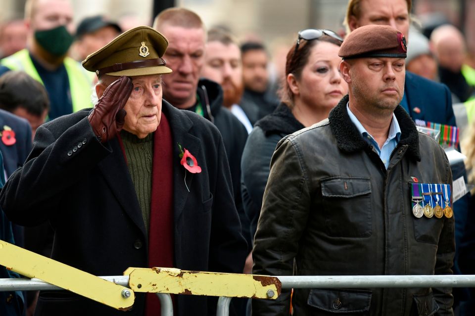 Veterans at the Cenotaph, one raises a hand in salute to the fallen soliders