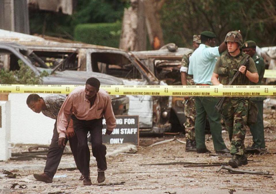 US soldiers stand guard outside the ruins in Tanzania