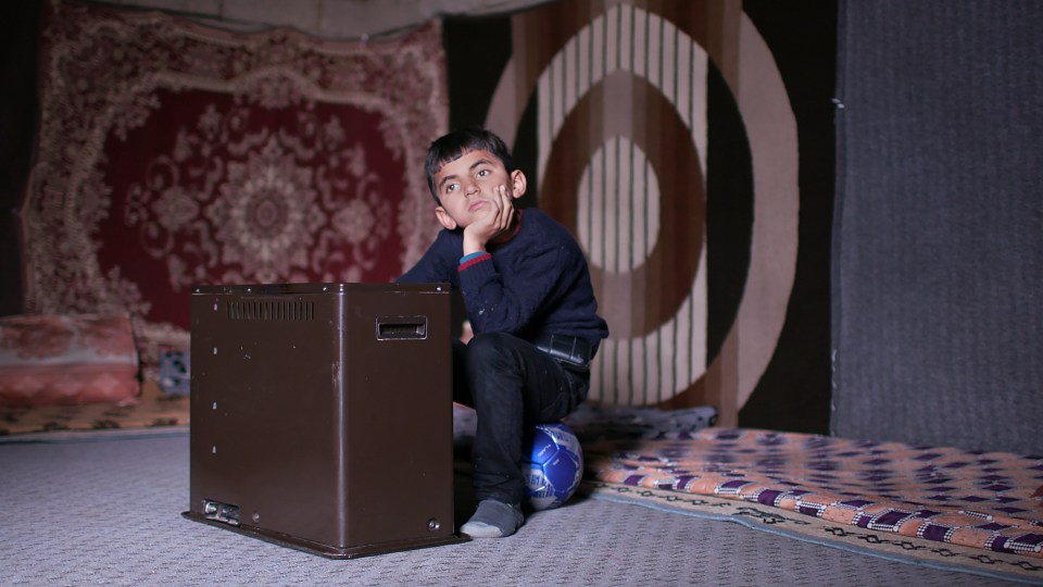 ISIS kidnapping victim Aham is pictured sitting on a blue and silver football