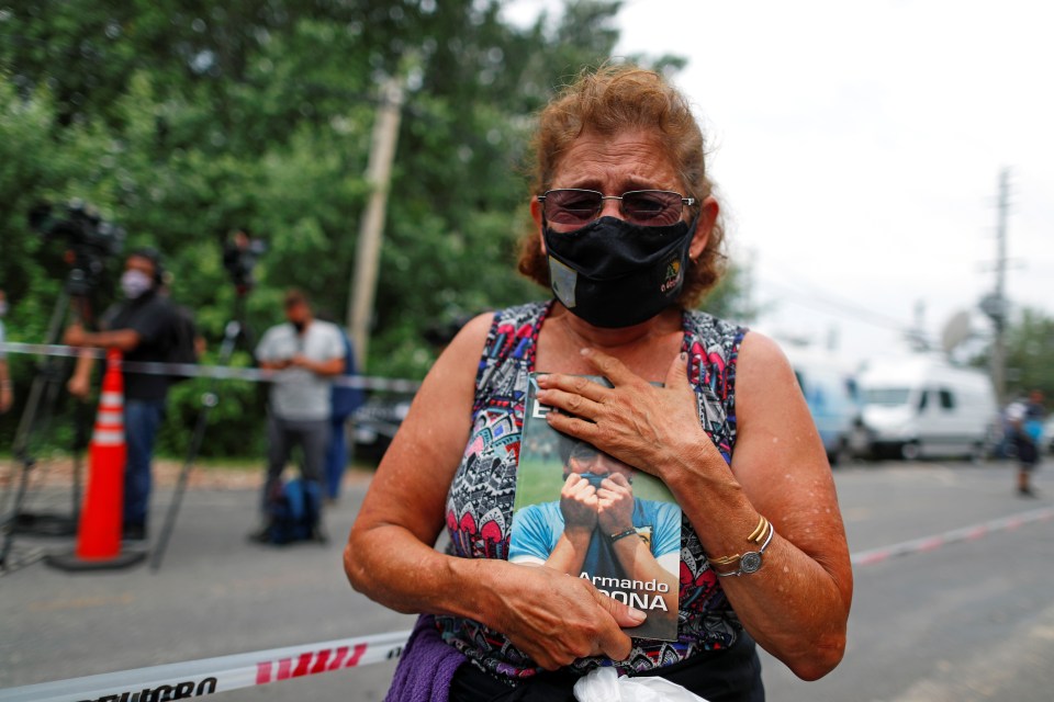 A woman clutches Maradona's book "Yo Soy Diego" outside the former footballer's house in Argentina 