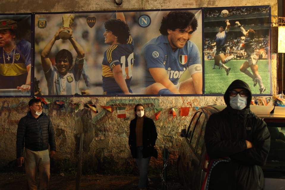 Fans stand beneath a mural of the legend in Argentina