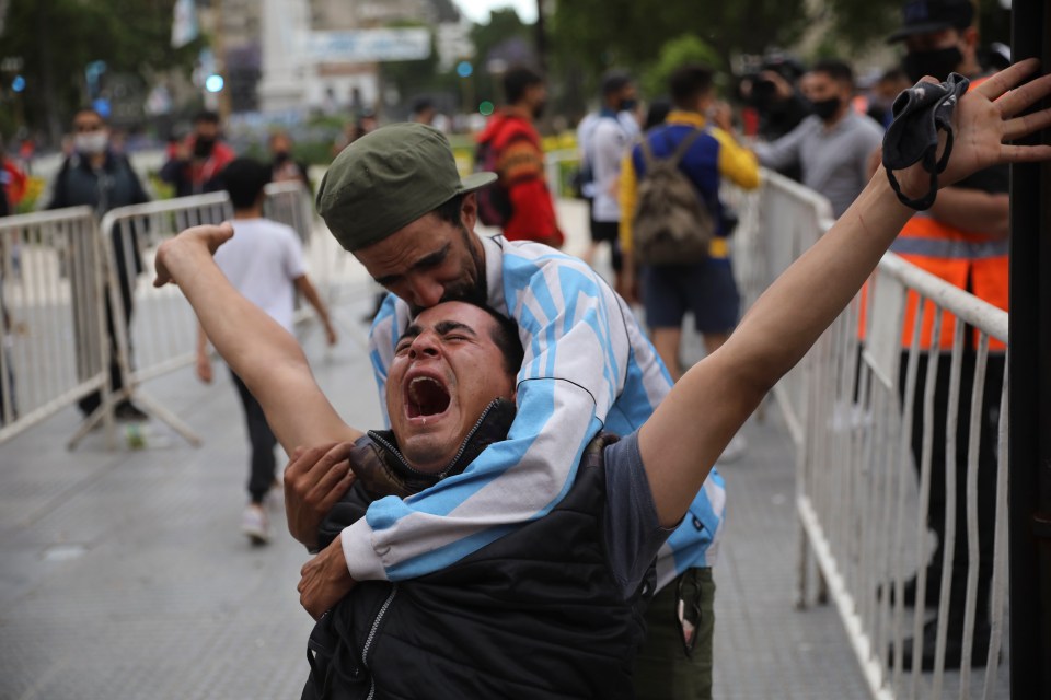 One man embraces his screaming friend amid the chaos 