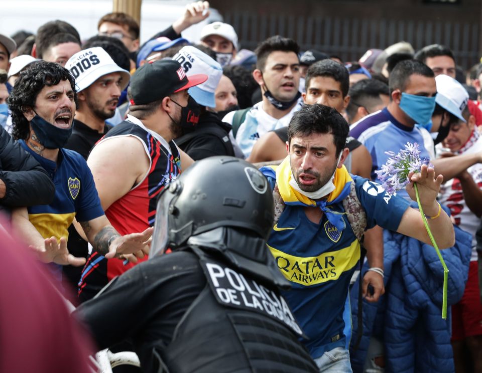 Fans carrying flowers grapple with cops