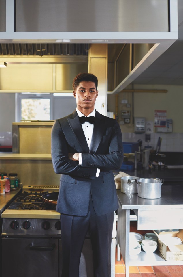 Marcus Rashford poses in a suit at his old school's kitchen