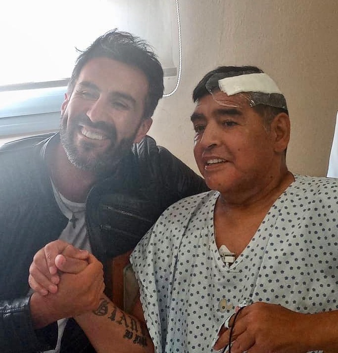 Maradona shakes hands with his doctor Leopoldo Luque after undergoing surgery for a brain bleed in what is believed to be his last picture