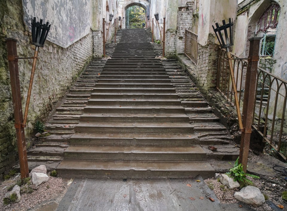 A vast step of crumbling stairs lead up to a spot of daylight at the castle