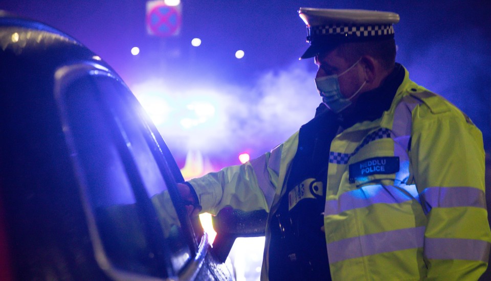 A cop conducts vehicle checks in Ystrad Mynach, Wales