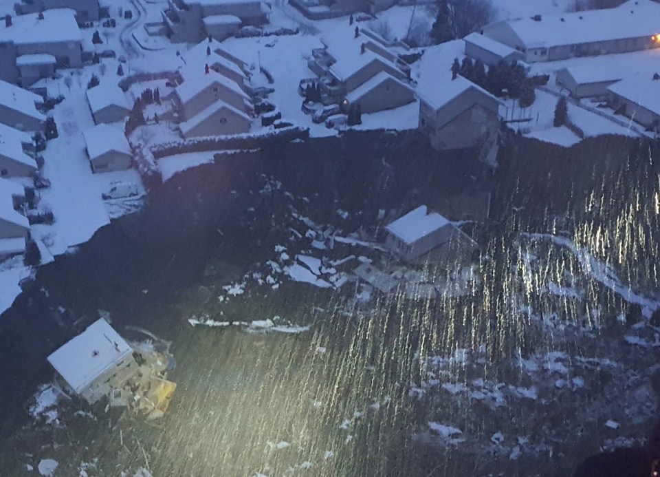 Houses can be seen to have been swept away by the torrent of rocks and earth