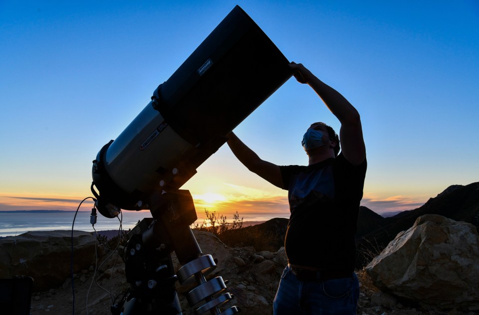 A man setting up his huge space telescope in California yesterday