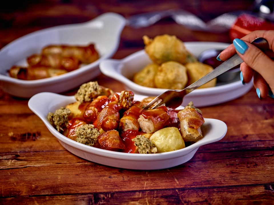 There's pigs in blankets, loaded roast potatoes topped with chopped pigs in blankets, stuffing, cranberry sauce and gravy, and even battered sprouts