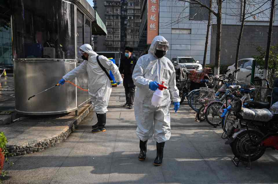 People dressed in protective clothing disinfecting an area in Wuhan in January