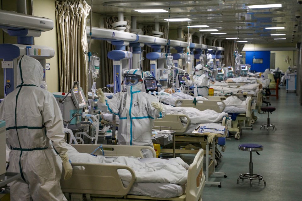 Medical workers in protective suits attend to Covid-19 patients at the intensive care unit (ICU) of a designated hospital in Wuhan