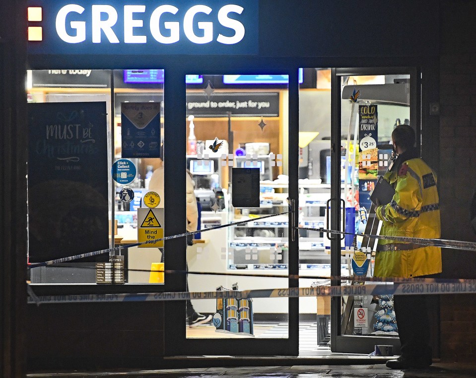 Police are seen outside the Greggs store in Droylsden after a woman was stabbed during a robbery