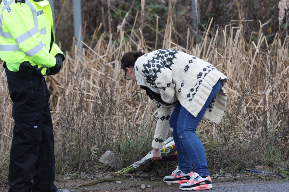 A grieving woman was also seen placing flowers in memory of the four people killed