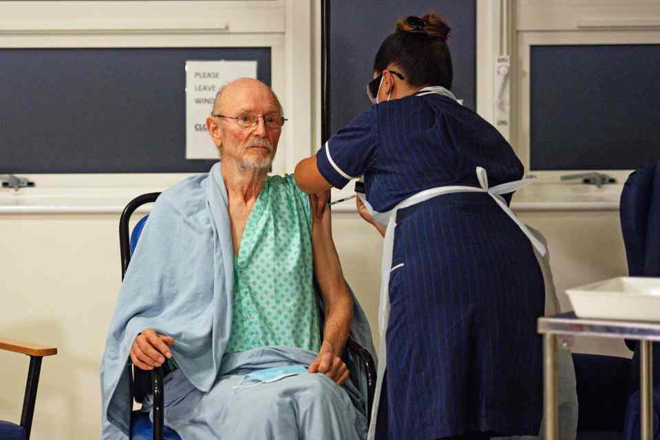 A nurse adminsters the Pfizer-BioNtech Covid-19 vaccine to patient William "Bill" Shakespeare, 81, at University Hospital in Coventry, December 8